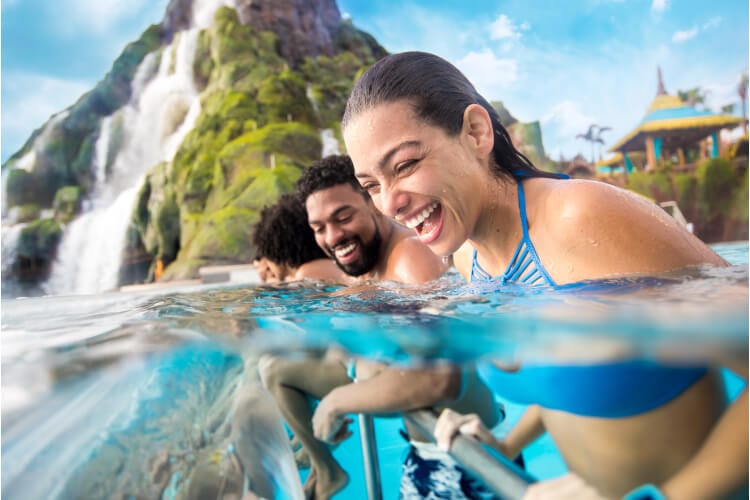 A couple laughs together as they enjoy time in the Reef Leisure Pool at Universal Volcano Bay.